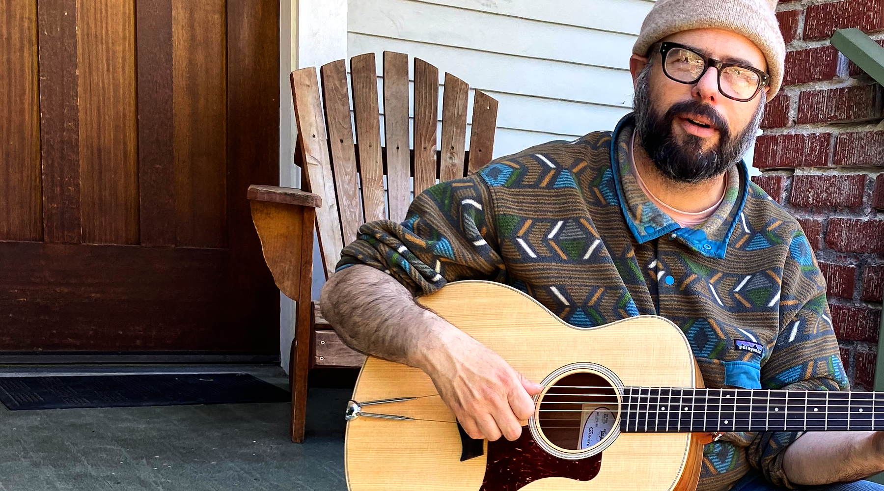 Bearded man on porch playing an acoustic guitar with the TurboTail installed